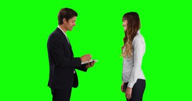 Beyaz tenli bir erkek satış danışmanı elinde bir dosya tutarken, beyaz bir kadın ev sahibine araba anahtarı verirken, yeşil ekranda gülümseyip el sıkışırken.