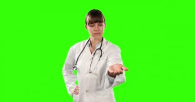 Kafkasyalı kadın bir doktorun, laboratuvar önlüğü ve steteskop giyip, yeşil ekran arka planında bir nesneyi tutar gibi elini uzattığını gördüm.