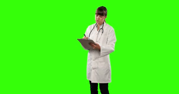 研究室のコートと聴診器を着た白人女性医師の正面図フォルダを保持し 緑の画面の背景にメモを書きます — ストック動画