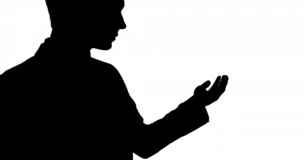 一个商人黑色轮廓的侧面视图 伸出他的手 就像拿着一个白色背景的物体 — 图库视频影像