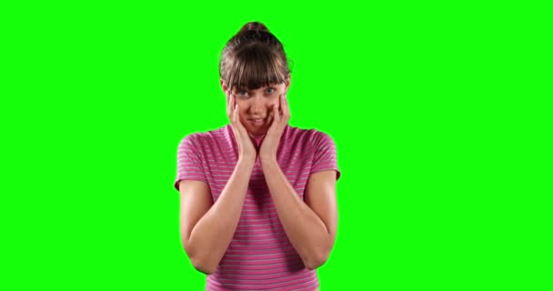 一个令人费解的白种人女人的画像 她留着一头乌黑的长发 穿着一件脱光的T恤衫 挥动双手 直勾勾地望着绿色背景的摄像机 — 图库视频影像