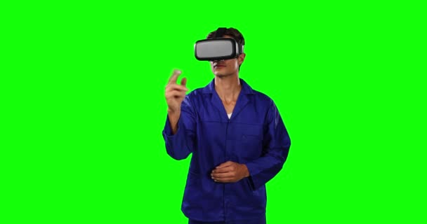作業服を着た白人男性技術者の車の整備士の正面図と 緑色の画面の背景に仮想スクリーンを指す仮想現実ヘッドセット — ストック動画