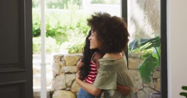 Karışık ırk kadını, kızıyla vakit geçirmekten zevk alıyor. Coronavirus kovid19 salgını sırasında karantinaya alınmış sosyal mesafeyi ve kendini izolasyonu yavaş çekimde kucaklıyor.