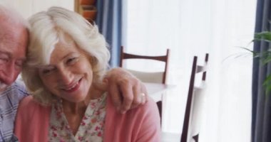 Üst düzey bir beyaz çiftin portresi evde birlikte vakit geçirir, bir koltukta oturur, kucaklaşır, gülümser ve kameraya bakar, koronavirüs sırasında kendilerini izole ederler..