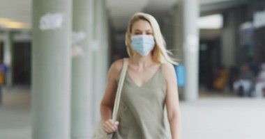 Coronavirus 'a karşı yüz maskesi takan beyaz bir kadının portresi. Gün boyunca şehir sokaklarında dolanıp kameraya bakıyor..