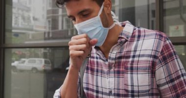 Coronavirus 'a karşı yüz maskesi takan beyaz bir adamın portresi. Gün boyunca şehir sokaklarında dolanıp, öksürürken ağzını kapatıyor..