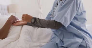 Melez bir ırk hemşiresi tarafından evine ziyaret edilen melez bir kadın. Konuşuyor, sosyal uzaklaşıyor ve kendini karantinaya alıyor. Yavaş çekimde.