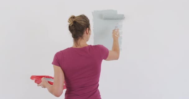 自宅で時間を過ごす白人女性 彼女の家を改装 コロナウイルスの流行の間に隔離されたロックダウンでの社会的距離と自己分離 スローモーションで壁を描く — ストック動画