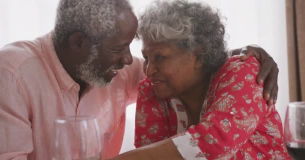 コロナウイルスの流行の間に隔離された隔離室で社会的距離と自己隔離を共に過ごすアフリカ系アメリカ人の高齢者のカップルは19の流行を覆い テーブルに座ってゆっくりとした動きを受け入れ笑顔 — ストック動画