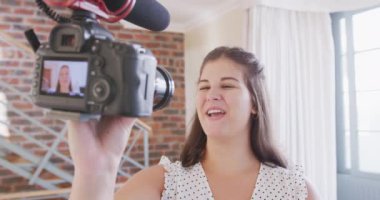 Beyaz kadın video blogcu, elinde kamera, video bloğu için video hazırlıyor. Karantina karantinasında sosyal uzaklık ve kişisel izolasyon.