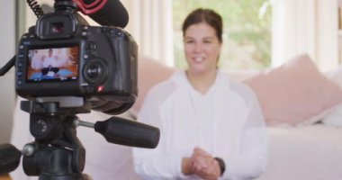 Kafkas kadın vlogger evde zaman geçiriyor, video bloğu için video hazırlıyor, alıştırmalar yapıyor. Karantina karantinasında sosyal uzaklık ve kişisel izolasyon.
