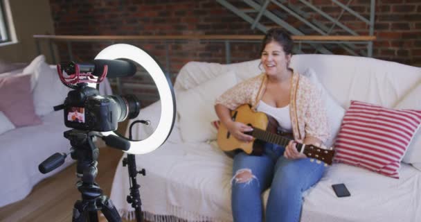 Vlogger Mujer Caucásica Casa Sala Estar Enseñando Tocar Una Guitarra — Vídeo de stock