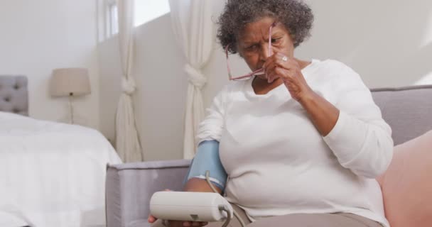 一名混合种族护士在家中探访混合种族妇女 缓慢地检查血压 社会疏离和隔离情况 — 图库视频影像