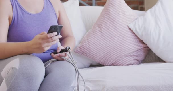 白人女性のVloggerは自宅で時間を過ごし 運動中に休憩を取り スマートフォンを使用しています 隔離された封鎖における社会的距離と自己隔離 — ストック動画