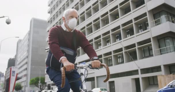 コロナウイルスに対してフェイスマスクを着用し 19をCovid 彼の自転車に乗って スローモーションで — ストック動画