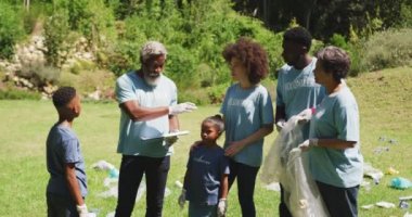 Çok nesildir karışık ırk aileleri bahçede vakit geçiriyorlar. Elinde evrak tutan, mavi gönüllü tişörtler giyen, çöp toplayan yaşlı melez bir adamı yavaş çekimde dinliyorlar.