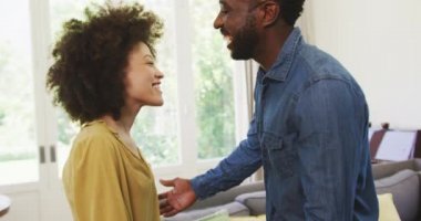 Karışık ırk çiftleri evlerinde vakit geçiriyorlar, kucaklaşıyorlar ve gülümsüyorlar, sosyal uzaklaşıyorlar ve kendilerini karantinaya alıyorlar Coronavirus covid19 salgını sırasında ağır çekimde karantina altına alıyorlar.