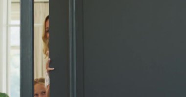 Beyaz kadın evde vakit geçirmekten zevk alıyor, kapıları açıyor, kameraya bakıyor ve gülümsüyor, sosyal uzaklık ve kişisel tecrit Coronavirus covid19 salgını sırasında ağır çekimde karantinaya alınıyor.