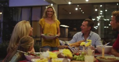 Çoklu nesil Kafkas ailesi evde vakit geçiriyorlar, masada birlikte yemek yiyorlar, bir kadın Coronavirüs sırasında karantina, sosyal uzaklık ve kendini izolasyon ile karantina altına almış 19 salgını sırasında yemek yiyor.