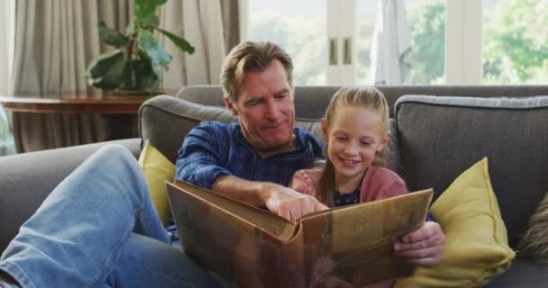 Chica Caucásica Disfrutando Tiempo Casa Sentada Sofá Con Abuelo Leyendo — Vídeos de Stock