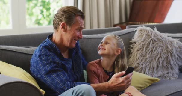 Chica Caucásica Disfrutando Tiempo Casa Sentada Sofá Con Abuelo Sosteniendo — Vídeos de Stock