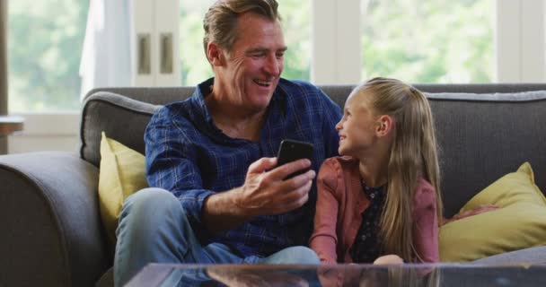 Chica Caucásica Disfrutando Tiempo Casa Sentada Sofá Con Abuelo Sosteniendo — Vídeos de Stock