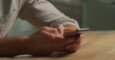 Kafkasyalı bir adamın evdeki vaktini, sosyal mesafeyi ve kendini karantinaya alıp bir masada akıllı telefon kullanarak geçirdiği orta bölüm.