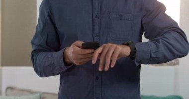 Kafkasyalı bir adamın evde vakit geçirdiği orta bölüm, sosyal mesafeler ve tecrit, oturma odasında duruyor, akıllı telefon ve akıllı kaset kullanıyor.