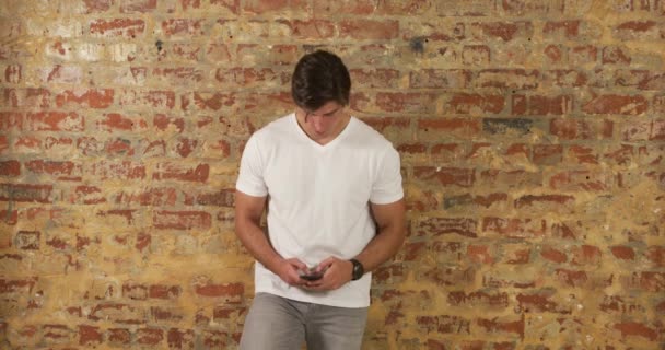 Hombre Caucásico Con Una Camiseta Blanca Jeans Grises Pie Contra — Vídeos de Stock