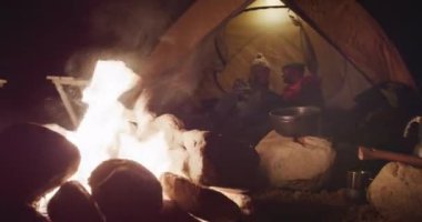 Kafkasyalı çift dağlara doğru bir yolculukta iyi vakit geçiriyorlar, gece bir kamp ateşinin yanında çadırda uzanıyorlar, öpüşüyorlar ve konuşuyorlar, ağır çekimde.