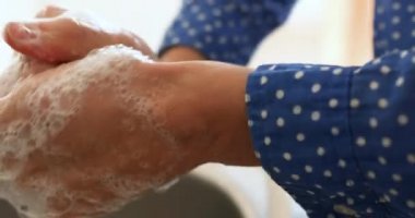 Beyaz bir kadının Coronavirus covid 19 salgını sırasında kendini izole ederek ve sosyal mesafeyi karantinaya alarak ellerini sabunla yıkayarak geçirdiği bölümün ortalarında.