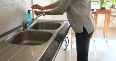 Beyaz bir kadının Coronavirus covid 19 salgını sırasında karantina altında kendini izole ederek ve sosyal mesafeyi koruyarak evde zaman geçirmesi, ellerini sabunla yıkaması.