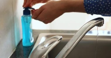 Beyaz bir kadının Coronavirus covid 19 salgını sırasında kendini izole ederek ve sosyal mesafeyi karantinaya alarak ellerini sabunla yıkayarak geçirdiği bölümün ortalarında.