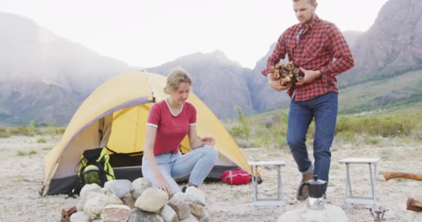 白种人夫妇在登山旅行中度过了一段愉快的时光 在阳光灿烂的一天 他们在帐篷前缓缓燃起篝火 — 图库视频影像