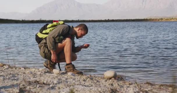 Caucasian Man Having Good Time Trip Mountains Crouching Lake Shore — Stock Video