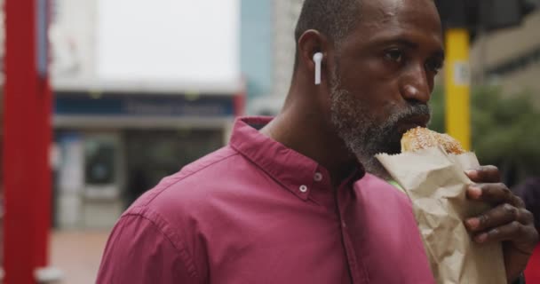 Hombre Afroamericano Por Las Calles Ciudad Durante Día Usando Auriculares — Vídeo de stock