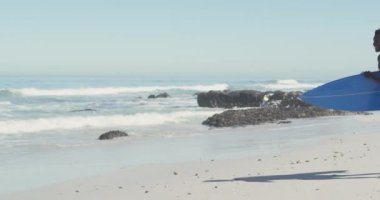 Afrika kökenli Amerikalı bir çiftin tropikal bir plajda güneşlenirken birbirlerine baktıkları mavi sörf tahtalarını ağır çekimde taşıyarak koşup durdukları görüntüler.