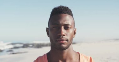 Afrikalı Amerikalı bir adamın portresi. Tropik bir plajda güneşin tadını çıkarıyor. Kameraya bakıyor ve gülümsüyor.