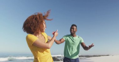 Afrika kökenli Amerikalı bir çiftin, tropikal bir plajda güneşlenirken, el ele tutuşup, gülümseyip, yürürken, ağır çekimde birbirlerine baktıklarını görüyorum.