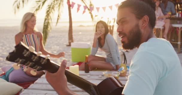 휴일에 친구들의 은연이지 해변에서 시간을 보내면서 식탁에 기타를 동작으로 연주하는 — 비디오