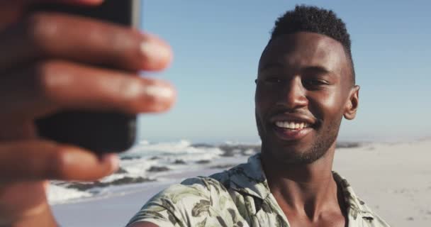 一个非裔美国人在热带海滩上享受阳光下的时光 面带微笑 慢吞吞地看着眼前的景象 — 图库视频影像
