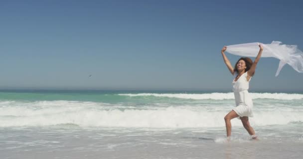 一个非洲裔美国女人在热带海滩上享受阳光下的时光 慢吞吞地跑来跑去 头上顶着一条围巾的侧影 — 图库视频影像