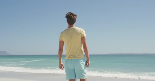 Vista Trasera Hombre Caucásico Disfrutando Del Tiempo Sol Una Playa — Vídeo de stock