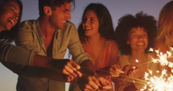 休日の友人の多民族グループのフロントビューは 日没時に熱帯のビーチで一緒に時間を楽しんで 笑顔と輝きと遊ぶ スローモーションで — ストック動画