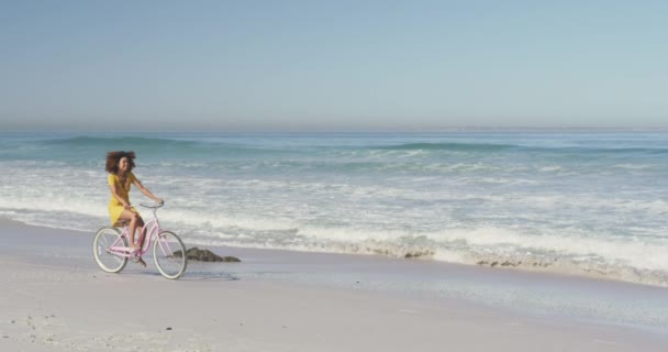 해변에서 자전거를 일광욕을 즐기며 천천히 아프리카 여성의 — 비디오