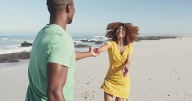 Afrika kökenli Amerikalı bir çiftin, tropikal bir plajda güneşlenirken, el ele tutuşup, gülümseyip, yürürken, ağır çekimde birbirlerine baktıklarını görüyorum.