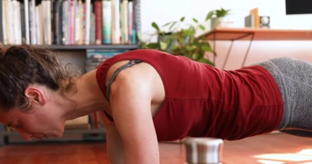 白种人女人穿着运动服 在大头牛期间呆在家里 围观禁锢 在客厅的瑜伽垫上锻炼 与外界保持距离和自我隔离 — 图库视频影像