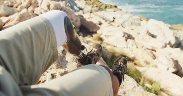 身材瘦小 身体残疾的混合型赛车手 在登山 坐在岩石上 在阳光灿烂的日子里 慢条斯理地活动着 — 图库视频影像