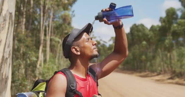 健康的 残疾的混合型赛车手 享受登山之旅 在森林里散步 休息一下 在阳光明媚的一天 慢吞吞地往脸上倒水 — 图库视频影像