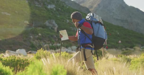 身强体壮 身弱力壮的混合型赛车手 喜欢登山 在土路上行走 使用北欧手杖 在阳光明媚的日子拿着地图 动作缓慢 — 图库视频影像